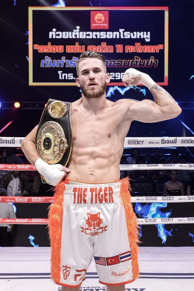 Florent Dervis, belt over his shoulder and fist raised